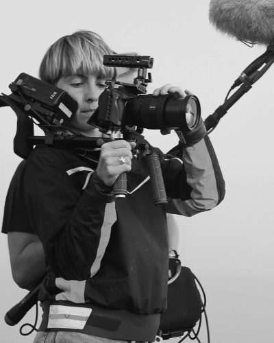 Femme qui tient une caméra et un micro sur perche